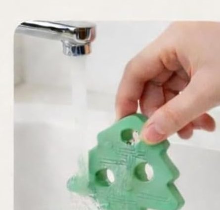 Rinsing a silicone tree piece clean under the tap