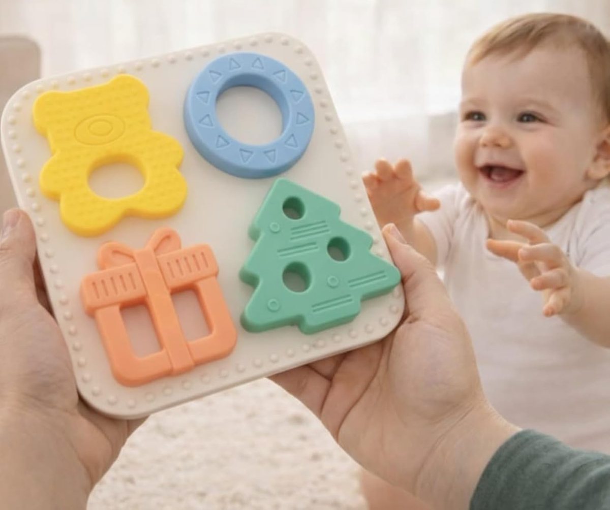 A parent holding the Babylul teether puzzle out to a delighted baby