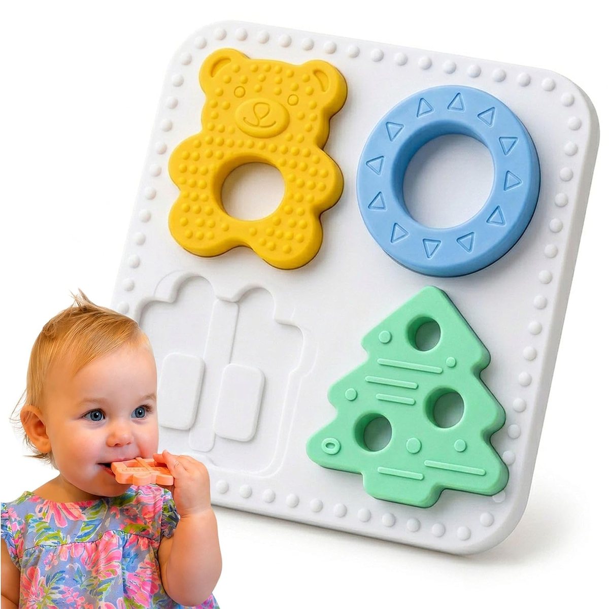 Baby chewing a Babylul silicone teether piece beside the puzzle board